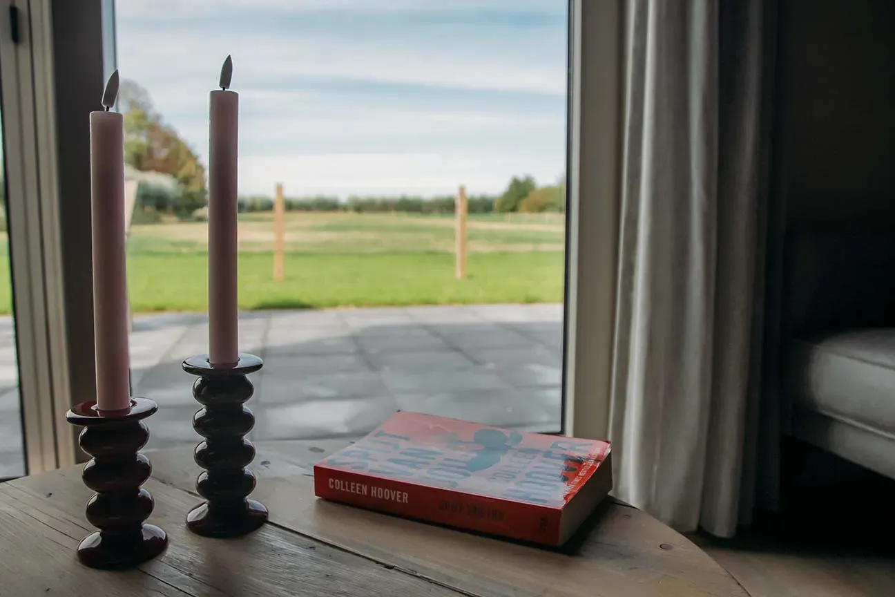 Boek en kaarsen bij het raam